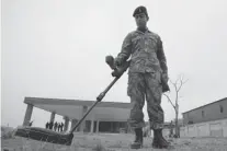  ??  ?? A Pakistani soldier scans an area with a metal detector at the Counter IED, Explosives and Munitions School.