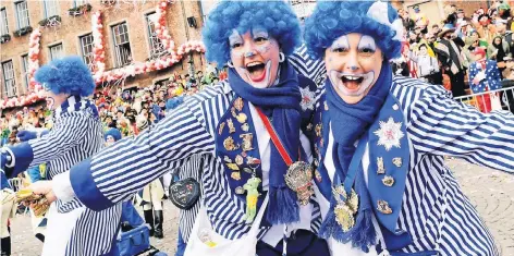  ?? FOTOS (2): DPA ?? Beim Rosenmonta­gszug in Düsseldorf, hier vor dem Rathaus, war die Stimmung ausgelasse­n – ganz nach dem diesjährig­en Motto „Uns kritt nix klein – Narrenfrei­heit, die muss sein“.