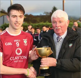  ??  ?? Michael Kilkenny, Shamrock Gaels captain, is presented with the U21 B trophy by Joe Taaffe, Co Board Chairman, after the game in Fr Kevin Brehony Memorial Park, Keash, on Sunday.