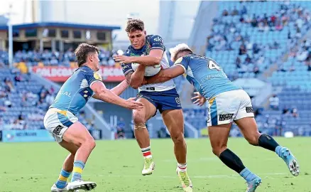  ?? GETTY ?? No way through for fullback Reece Walsh in the Warriors’ 20-18 loss to the Titans on the Gold Coast.