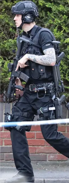  ??  ?? Armed: An officer with a semi-automatic rifle yesterday