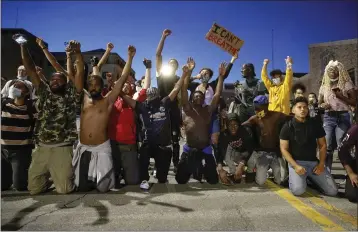  ?? BRYON HOULGRAVE — THE DES MOINES REGISTER ?? Protesters take their knees on 2nd Street during a protest in Des Moines. Protests have been erupting all over the country after George Floyd died earlier this week in police custody in Minneapoli­s.