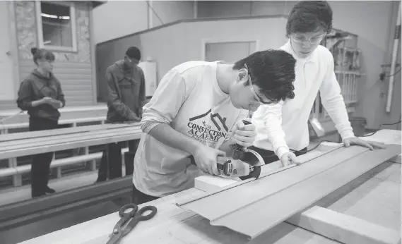  ?? DAX MELMER ?? High school students such as Jordan Tannous, left, and Carson Hollinsky learn to work with tools in the Constructi­on Academy at St. Joseph’s Catholic High School.