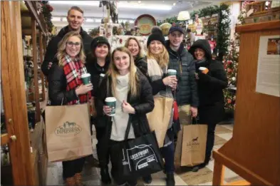  ?? LAUREN HALLIGAN — THE SARATOGIAN ?? A group goes shopping on Black Friday morning in Impression­s of Saratoga on Broadway in downtown Saratoga Springs.