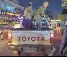  ?? AFP ?? Taliban fighters are seen standing on a pickup truck outside a hospital where injured people were being treated, in Kabul.