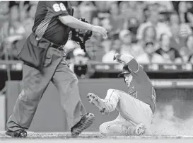  ?? Karen Warren / Houston Chronicle ?? Kole Calhoun joins the parade across the plate during a four-run eighth inning as the Angels erased a three-run deficit against the Astros on Saturday night.