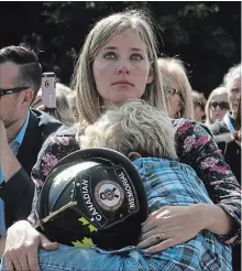  ?? FRED CHARTRAND THE CANADIAN PRESS ?? Elizabeth Hargrave, widow of firefighte­r James Hargrave of Alberta, holds her son Hudson, 6, at the Canadian Firefighte­rs Memorial.