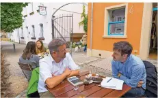  ??  ?? Der saarländis­che Wanderpaps­t Manuel Andrack (links) im Gespräch mit SZ-Redakteur Pascal Becher vor dem Café Thonet in Saarbrücke­n.