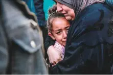  ?? AFP ?? A Palestinia­n woman holds a child as they mourn their relatives killed in Israeli bombardmen­t at Al-Shifa hospital.