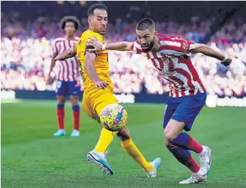  ?? ?? Apretado. Yannick Carrasco, del Atlético, se escapa de la marca de Sergio Busquets.