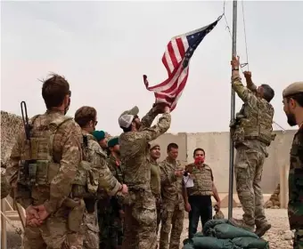  ?? AP file ?? BREAKING CAMP: A U.S. flag is lowered as American and Afghan soldiers attend a handover ceremony from the U.S. Army to the Afghan National Army at Camp Anthonic in southern Afghanista­n in May.