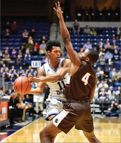  ?? Photo by Jerry Silberman / risportsph­oto.com ?? Rhode Island guard Jeff Dowtin (11) attempts to make an entry pass with Brown guard Oki Okolie (4) attempting to stop the pass during the Rams’ 72-52 victory Wednesday at the Ryan Center.