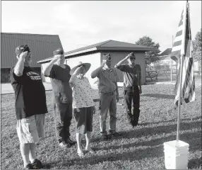  ?? Photo by Susan Holland ?? Officers of John E. Tracy American Legion Post 25 in Gravette stood and gave a farewell salute following their annual flag retirement ceremony on Flag Day. The ceremony was held on the grounds of the Gravette Civic Center. Officers pictured are Al Blair, finance officer (left); Mark Russow, second vice-commander; Rose Crose, chaplain; William Crose, first vice-commander; and Dave Malczynski, commander. Mike Carnahan, adjutant, was not present.