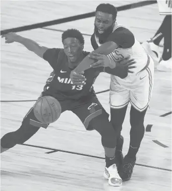  ?? KEVIN COX/GETTY ?? The Celtics’Jaylen Brown (7) and the Heat’s Bam Adebayo (13) fight for a loose ball during the fourth quarter Sunday in Lake Buena Vista, Fla.