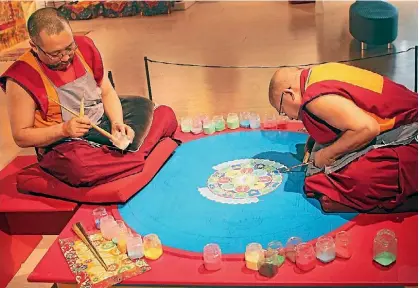  ??  ?? The monks use a cone-shaped metal funnel called a chak-pur to pour the sand.