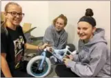  ?? SUBMITTED PHOTO ?? Skye Zolomij, Anna Dolan and Molly Dolan, all of West Chester, work on a bike at Pine Street Carpenters “100 Wheels Project” bike-build.