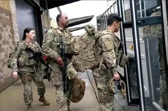  ?? Chris Seward/Associated Press ?? U.S. Army soldiers with their gear board an awaiting bus Saturday at Fort Bragg, N.C.