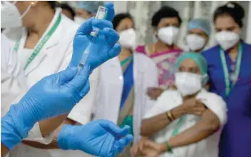  ?? — AFP ?? A nurse prepares to administer a COVID-19 coronaviru­s vaccine to health workers at the KC General Hospital in Bangalore.