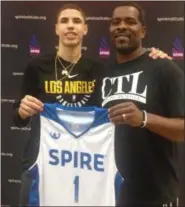  ?? JOHN KAMPF — THE NEWS-HERALD ?? LaMelo Ball shows off his new SPIRE basketball uniform along with SPIRE coach Jermaine Jackson on Nov. 10 in Geneva.