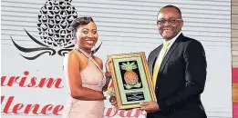  ??  ?? Shanique Cunningham of Sandals Royal, Individual winner for the Montego Bay region, accepts her plaque from Director of Tourism Donovan White.