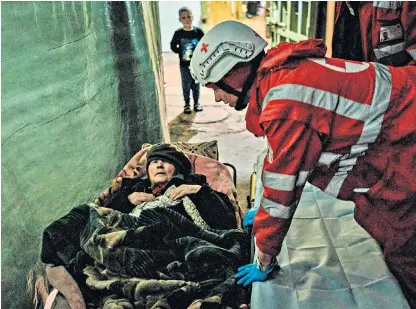  ?? ?? Children apparently taking shelter in the besieged Azovstal steelworks in Mariupol, right; above, a Red Cross worker talks to a displaced 92-yearold woman in eastern Ukraine; left, an injured soldier smokes outside a hospital in Kramatorsk