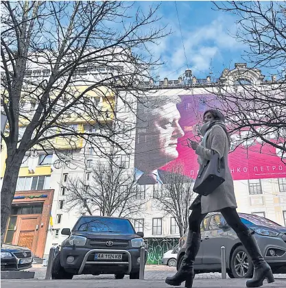  ?? AFP ?? „Kandidaten gibt es viele, Präsidente­n nur einen“– und damit meint Petro Poroschenk­o (im Bild ein Wahlplakat in Kiew) sich selbst.