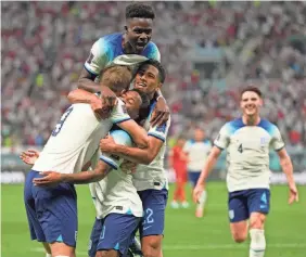  ?? FRANK AUGSTEIN/AP ?? Raheem Sterling celebrates with teammates after scoring England’s third goal against Iran.