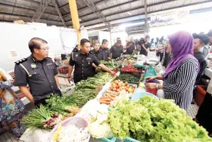  ?? -Gambar Bernama ?? CHIN (kiri) mengadakan pemeriksaa­n harga barangan keperluan harian di Pasar Awam Jitra pada Ahad.