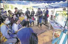  ?? AP ?? Family members watch a video of the trapped boys on television.