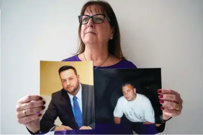  ?? The Associated Press ?? ■ Cheryl Juaire stands with photos of her sons who died from overdoses, Sean Merrill, left, and Corey Merrill, after making a statement Thursday during a hearing in New York. Victims of opioids and those who have lost loved ones to the addiction crisis were unleashing their emotions on members of the family they blame for fueling the deadly epidemic. Thursday’s unusual hearing was being conducted virtually in U.S. Bankruptcy Court in New York. It was giving people the chance to confront members of the Sackler family who own OxyContin maker Purdue Pharma and tell them about the lasting pain that addiction and overdoses have had in their lives.