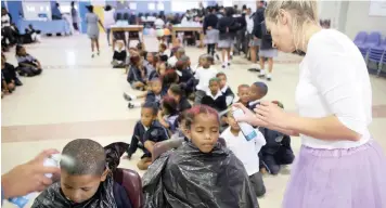  ?? BRENDAN MAGAAR African News Agency (ANA) ?? PUPILS at Forest Village Leadership Academy in Blue Downs spray their hair as part of raising funds for the school’s receptioni­st, Hayley Daniels, who has been diagnosed with stage 3 breast cancer. |