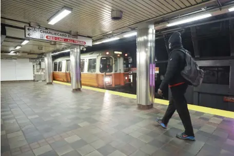  ?? NICOLAuS CzARnECkI PHOTOS / HERALD STAFF FILE ?? FEW RIDERS: An Orange Line train pulls into a quiet Downtown Crossing Station on Dec. 8 as ridership on the MBTA continues to be low due to the pandemic. Below, the train remains near-empty as it pulls out of the station.