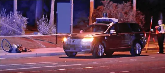  ??  ?? Fatal crash: The self-driving car and a bicycle – thought to be the victim’s – at the scene of the accident in Arizona yesterday