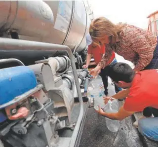  ?? ?? Vecinos de Peñarroya llenan ayer las garrafas de agua potable //A. CARMONA