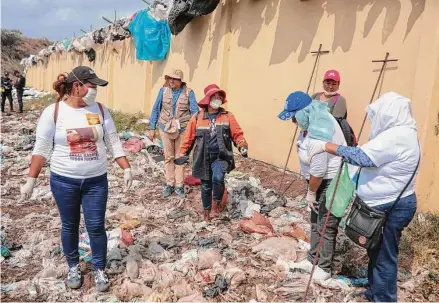  ?? Felix Marquez/Associated Press ?? Members of a “colectivo” sink iron rods into the ground in 2019 to detect decomposin­g bodies in Veracruz, Mexico.