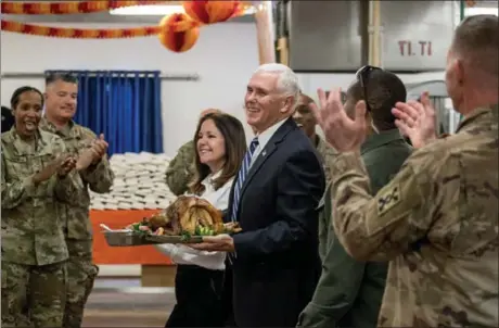  ?? ANDREW HARNIK — THE ASSOCIATED PRESS ?? Vice President Mike Pence and his wife, Karen, arrive with turkey Saturday to serve to troops at Al Asad Air Base, Iraq, in a pre-Thanksgivi­ng feast. The visit is Pence’s first to Iraq.