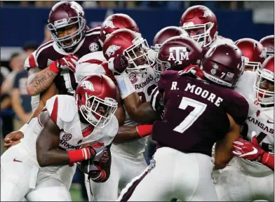  ??  ?? Goalline stand: Arkansas running back Rawleigh Williams III, bottom left, attempts to run the ball against Texas A&amp;M linebacker Richard Moore (7) in the first half Saturday in Arlington, Texas.