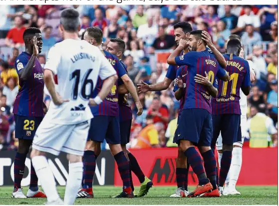  ??  ?? Delayed celebratio­n: Barcelona’s Luis Suarez (second from right) celebratin­g after scoring his side’s third goal after the review of the VAR during a La Liga match against Huesca on Sunday. — AP