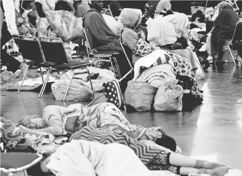  ?? HENRIETTA WILDSMITH, USA TODAY NETWORK ?? Evacuees rest Tuesday at the George R. Brown Convention Center in Houston. The facility’s website has links to donation sites.