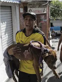  ?? Leo Correa /AP ?? Homem com cão que teria se ferido em tiroteio na Rocinha PARATY
