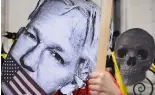  ?? ?? Un manifestan­t tient un masque de Julian Assange devant les Cours royales de justice à Londres, mardi 20 février 2024.