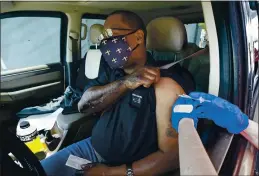  ?? GERALD HERBERT — THE ASSOCIATED PRESS ?? Brian Snipes receives a drive-thru vaccinatio­n on Monday at “Vaccine Fest,” a 24-hour COVID-19 mass vaccinatio­n event in Metairie, La., just outside New Orleans, hosted by Ochsner Health System and the Jefferson Parish Government.