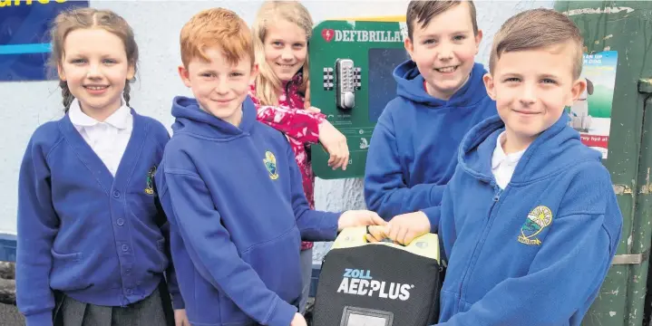  ??  ?? Pupils from Cwmdar Primary School with the first defibrilla­tor to be installed in the village