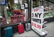  ?? MARY ALTAFFER— ASSOCIATED PRESS ?? A sign announcing a special on T- shirts is placed on the sidewalk outside a gift shop in Lower Manhattan, Tuesday, Nov. 17, 2020. In souvenir shops from Times Square to the World Trade Center, shelves full of T- shirts and trinkets still love New York, as the slogan goes. But the proprietor­s wonder when their customers will, again. The coronaviru­s has altered many aspects of life and business in the United States’ biggest city, and the pandemic is taking a major toll on the gifts- and- luggage stores that dot tourist- friendly areas. After setting records year after year since 2010, travel to Newyork has plummeted during the pandemic.