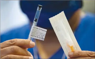  ?? STEVE MARCUS ?? A nurse holds a syringe with the Pfizer COVID-19 vaccine Dec. 16 at the VA Southern Nevada Healthcare System in North Las Vegas. Government and nonprofit health and community services organizati­ons are expanding their COVID-19 educationa­l campaigns about the newly released vaccines in a variety of languages to engage the Las Vegas Valley’s various cultural segments.