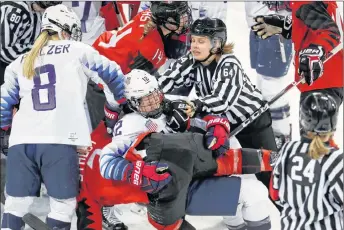  ?? AP PHOTO ?? Official Jenni Heikkinen (64) of Finland tries to separate Kelly Pannek (12) of the United States and Laura Stacey (7) of Canada as they scuffle during the third period of Thursday’s game. Canada won 2-1.