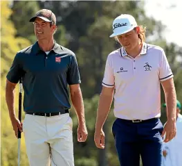  ??  ?? Australian­s Adam Scott, left, and Cameron Smith walk on to the 18th green during a practice round for the Masters at Augusta National Golf Club.