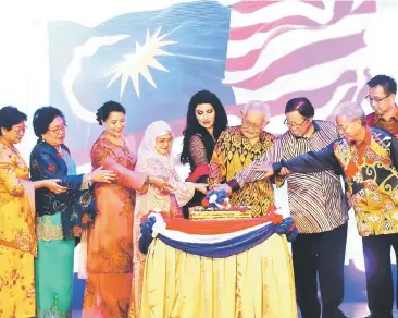  ??  ?? Taib (fourth right) and Raghad (fifth left), Abang Johari (third right) and other dignitarie­s cutting the cake during the state-level Malaysia Day celebratio­n.