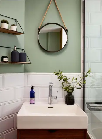  ??  ?? Right The compact bathroom makes the most of a small space, with an over-bath shower and sink tucked between the bath and angled wall.
Tiles, Topps Tiles. Vanity unit, Elle Decoration for Bathstore. Bath, Duravit. Brassware, Hans Grohe. Mirror and shelves, Cox
& Cox. Walls painted in Pearl Green, Dulux