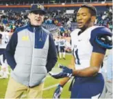  ??  ?? Valor’s Will Rodgers talks with Michigan coach Jim Harbaugh on Saturday. Joe Amon, The Denver Post